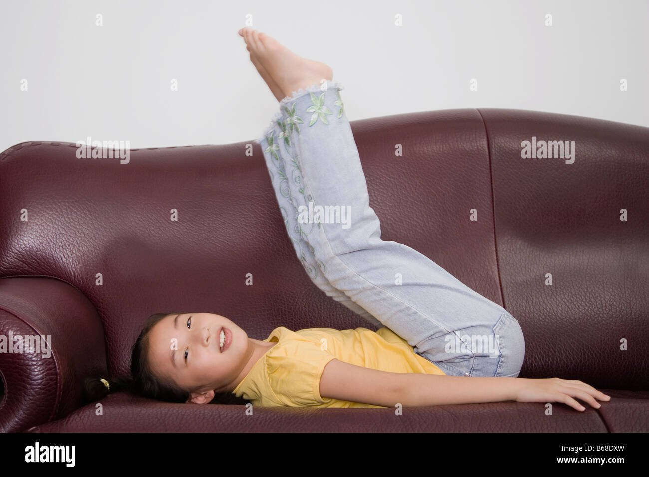 Seitenansicht eines Mädchens, das Spielen auf einer couch Stockfoto