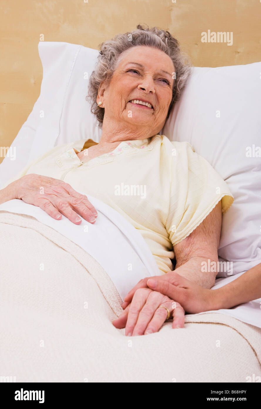 Frau mit senior Frauenhand auf Bett Stockfoto