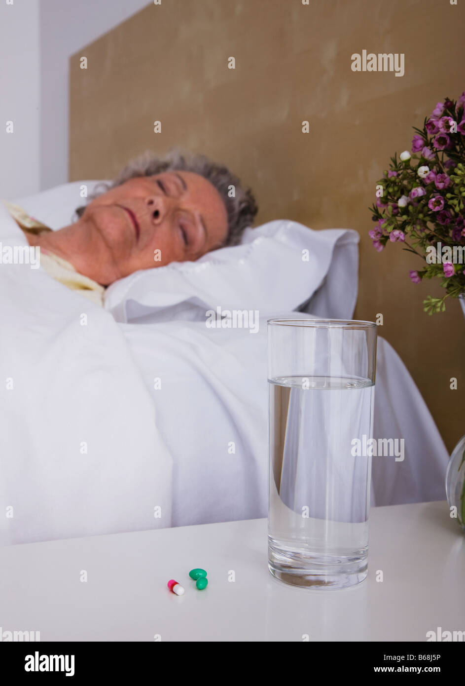 Ältere Frau schlafend im Bett Stockfoto