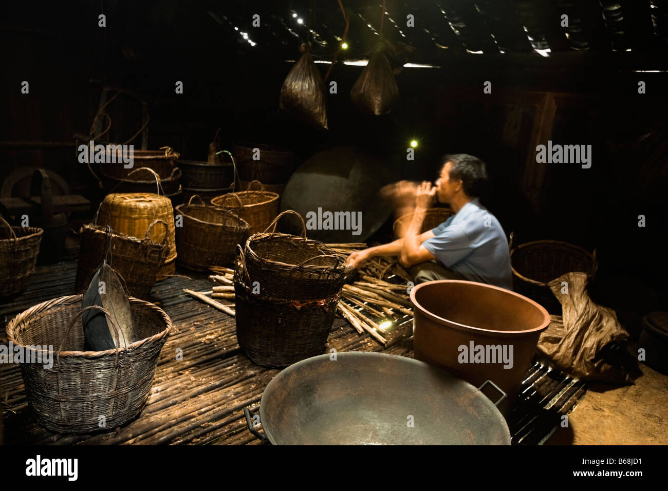 Seitenansicht eines reifen Mannes weben ein Bambus Korb, Jinkeng Reihenhaus Feld, Provinz Guangxi, China Stockfoto