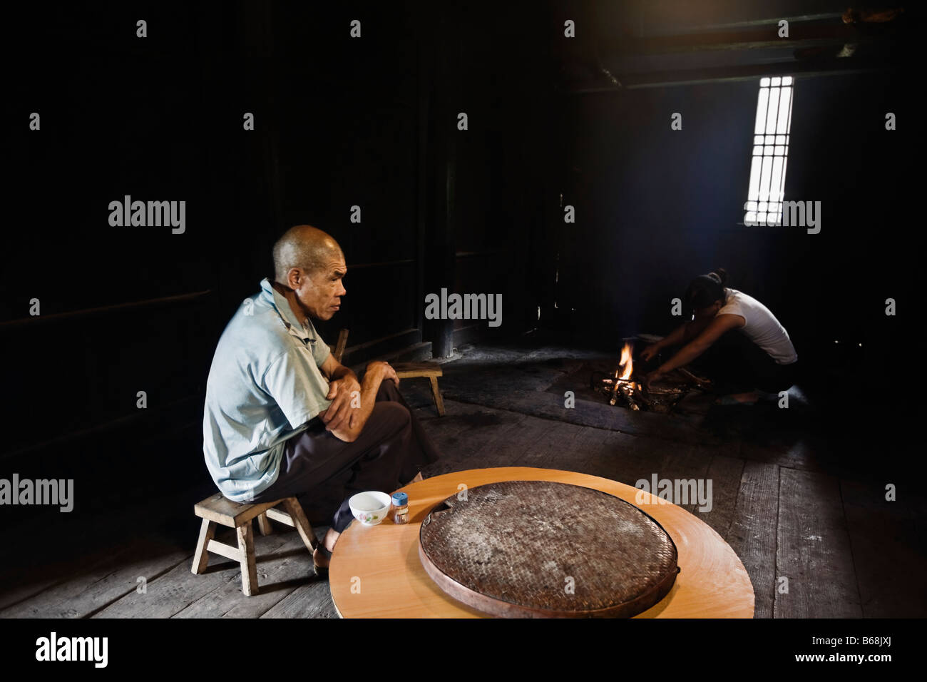 Seitenansicht eines Senior Mann bereitet Essen, Jinkeng Reihenhaus Feld, Provinz Guangxi, China Stockfoto