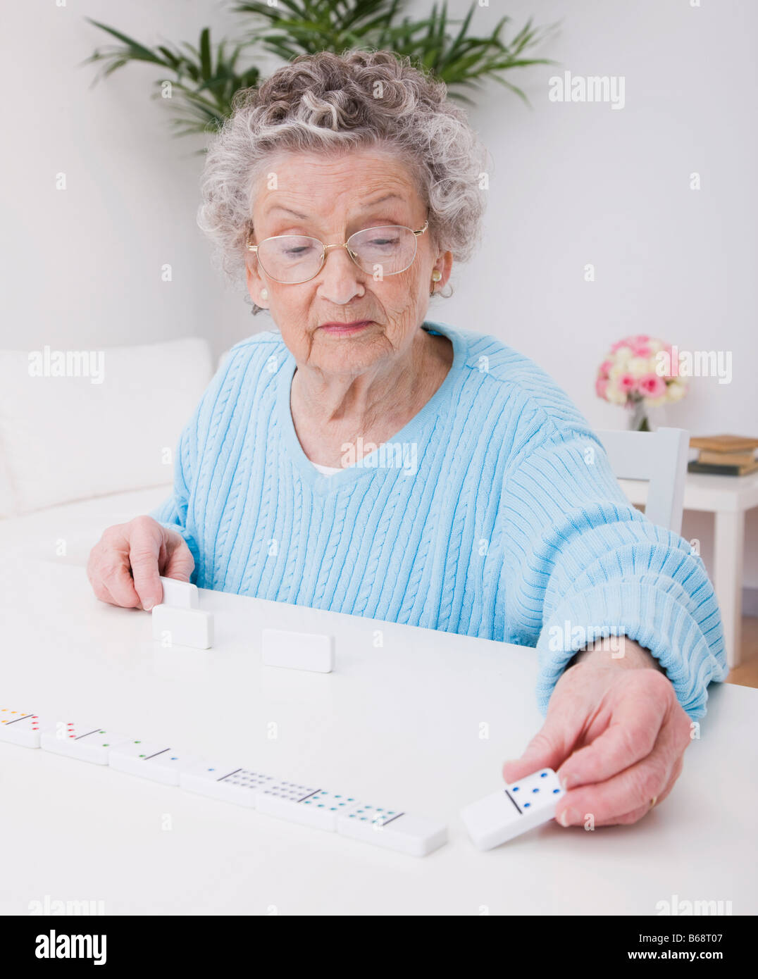 Ältere Frau Domino spielen Stockfoto