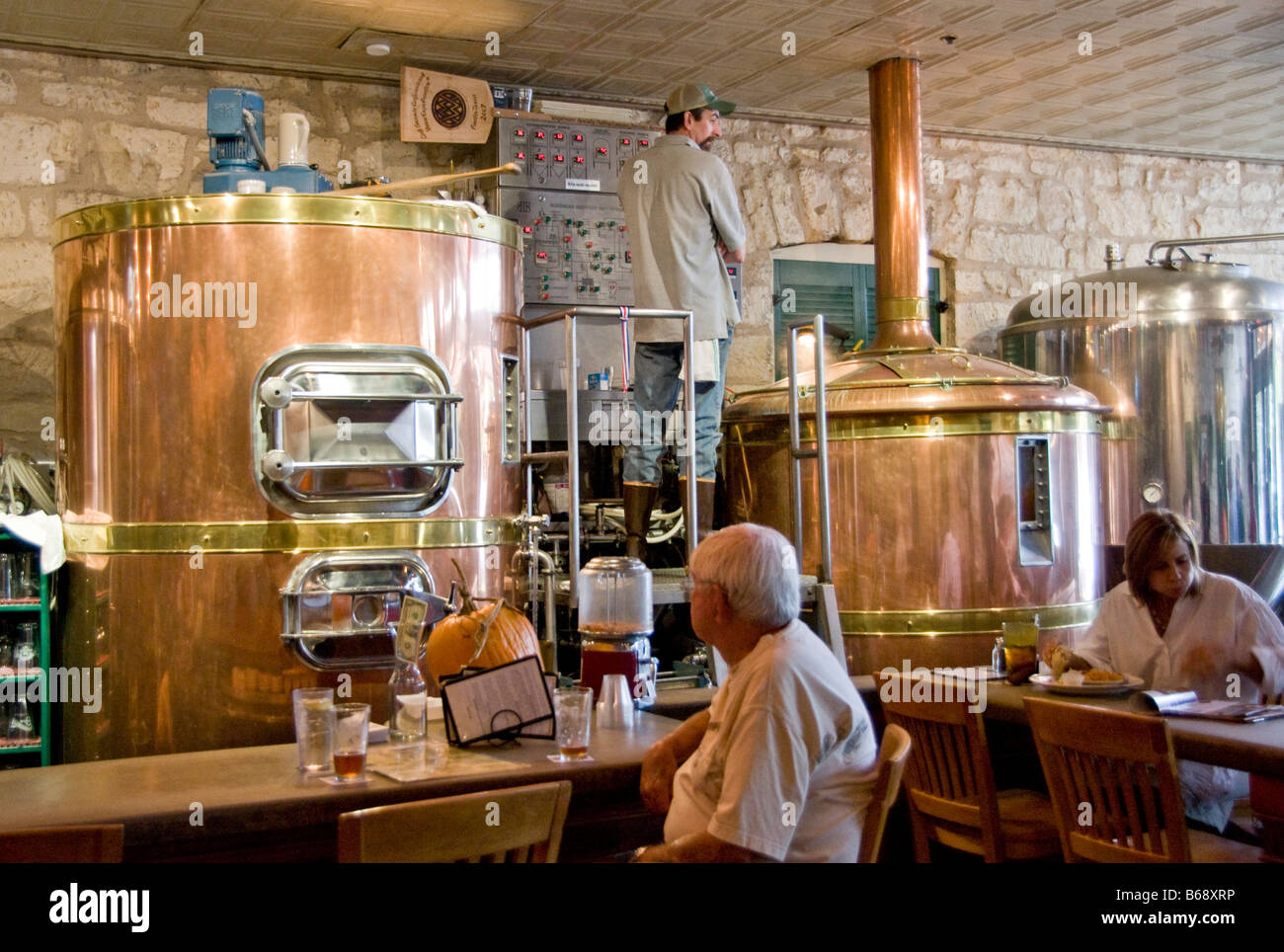 Texas Hill Country, Fredericksburg Brewing Company, Braumeister mit Brauereitanks in restaurant Stockfoto