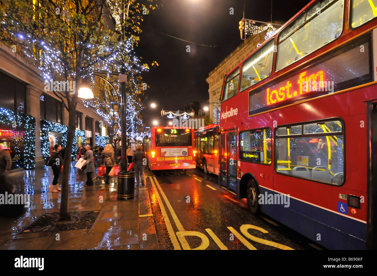 Oxford Street Shopper und Weihnachten Dekorationen London Bus beleuchteten Werbetafel im Regen draußen Selfridges Shop Stockfoto