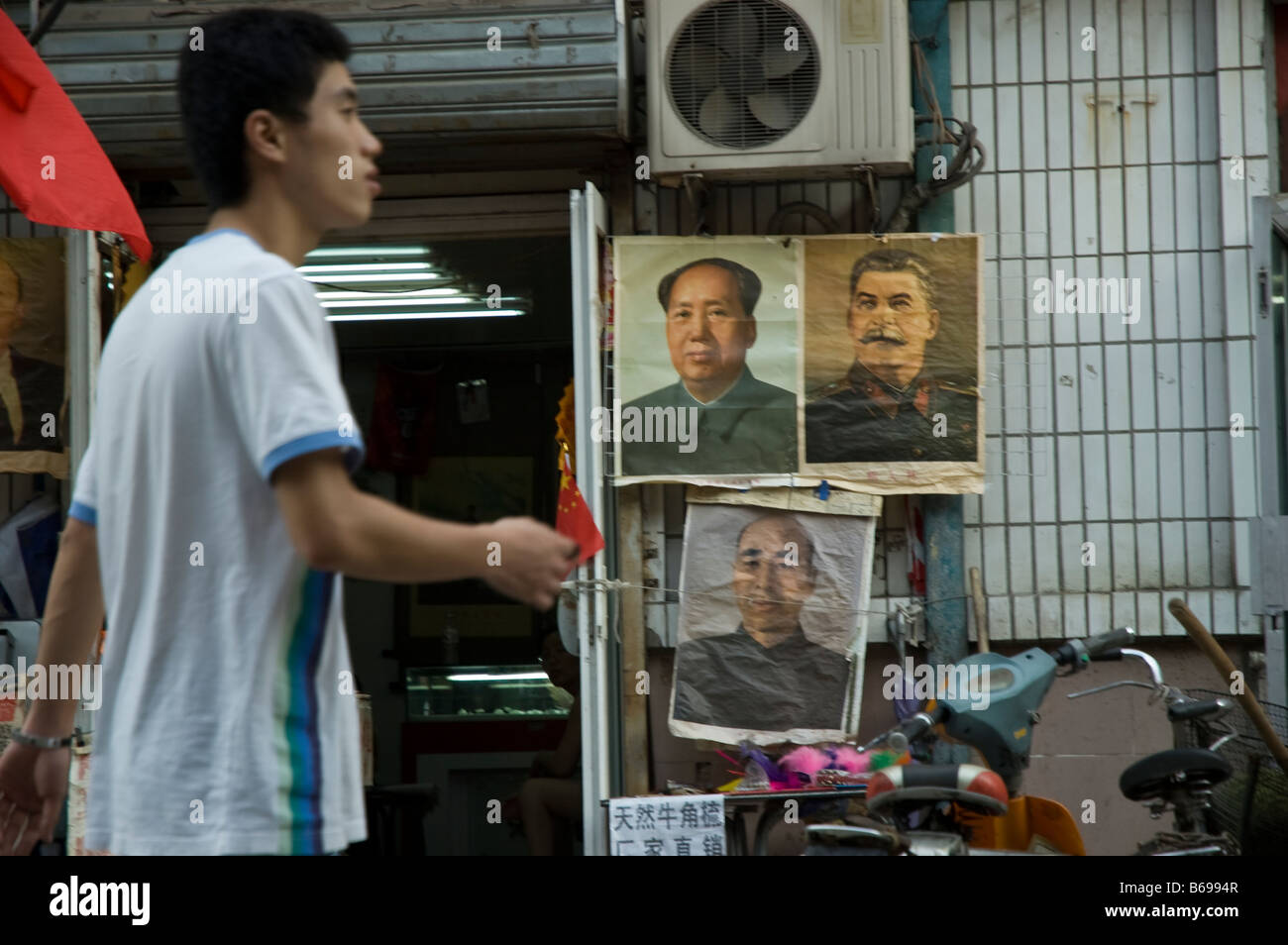 ein Bürger von Peking geht durch Plakate von Mao Zedong Joseph Stalin und Lin Biao Stockfoto