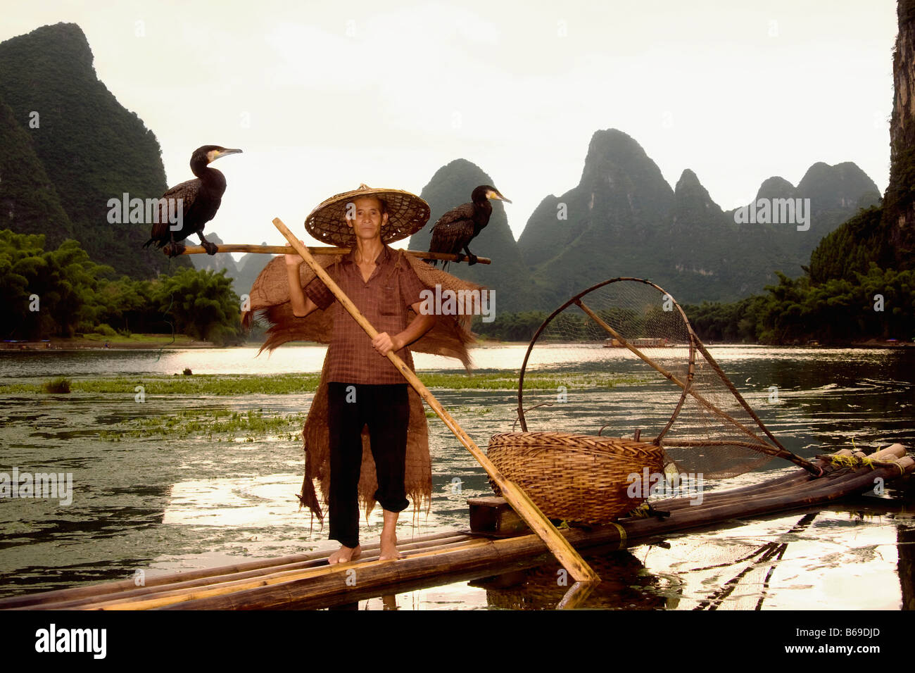 Ältere Mann auf einem Bambus Rafting mit verschiedensten Hügel im Hintergrund, Guilin Hügeln, XingPing, Yangshuo, Provinz Guangxi, China Stockfoto