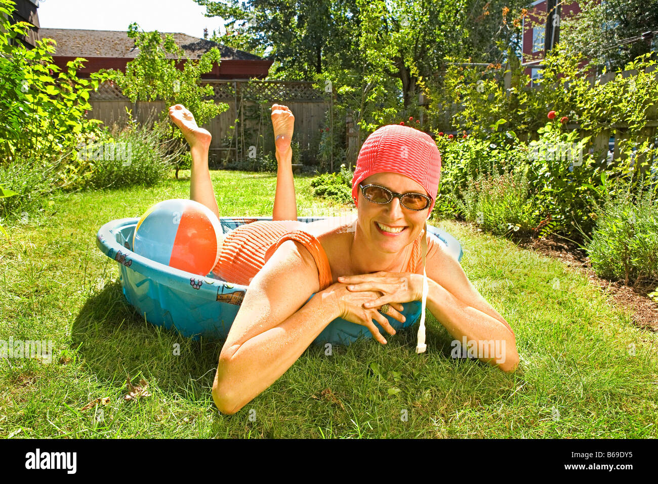 Frau liegend in einem Planschbecken und lächelnd Stockfoto