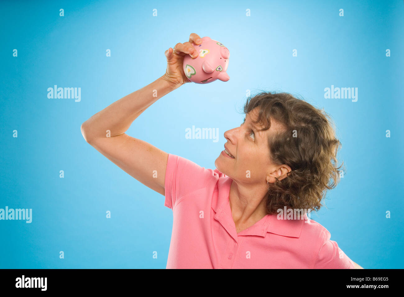 Frau, die versucht, Geld aus einem Sparschwein Stockfoto