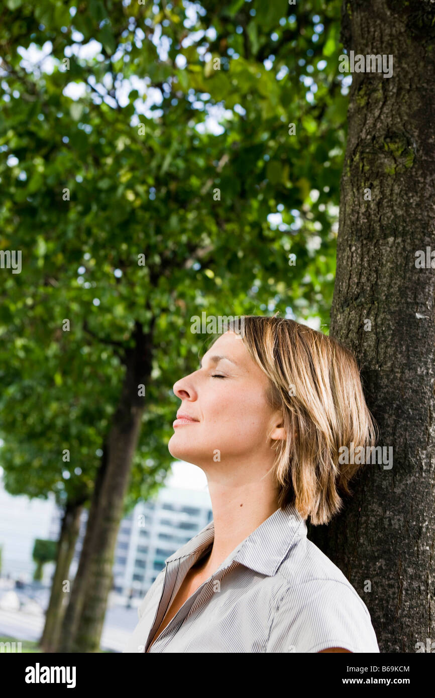 Frau am Baum gelehnt Stockfoto