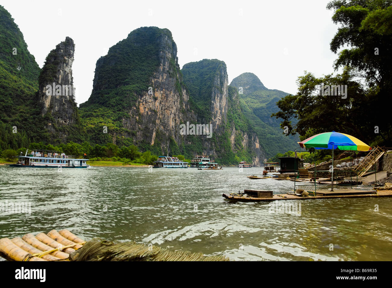 Flusskreuzfahrtschiffe in einem Fluß, XingPing, Yangshuo, Provinz Guangxi, China Stockfoto