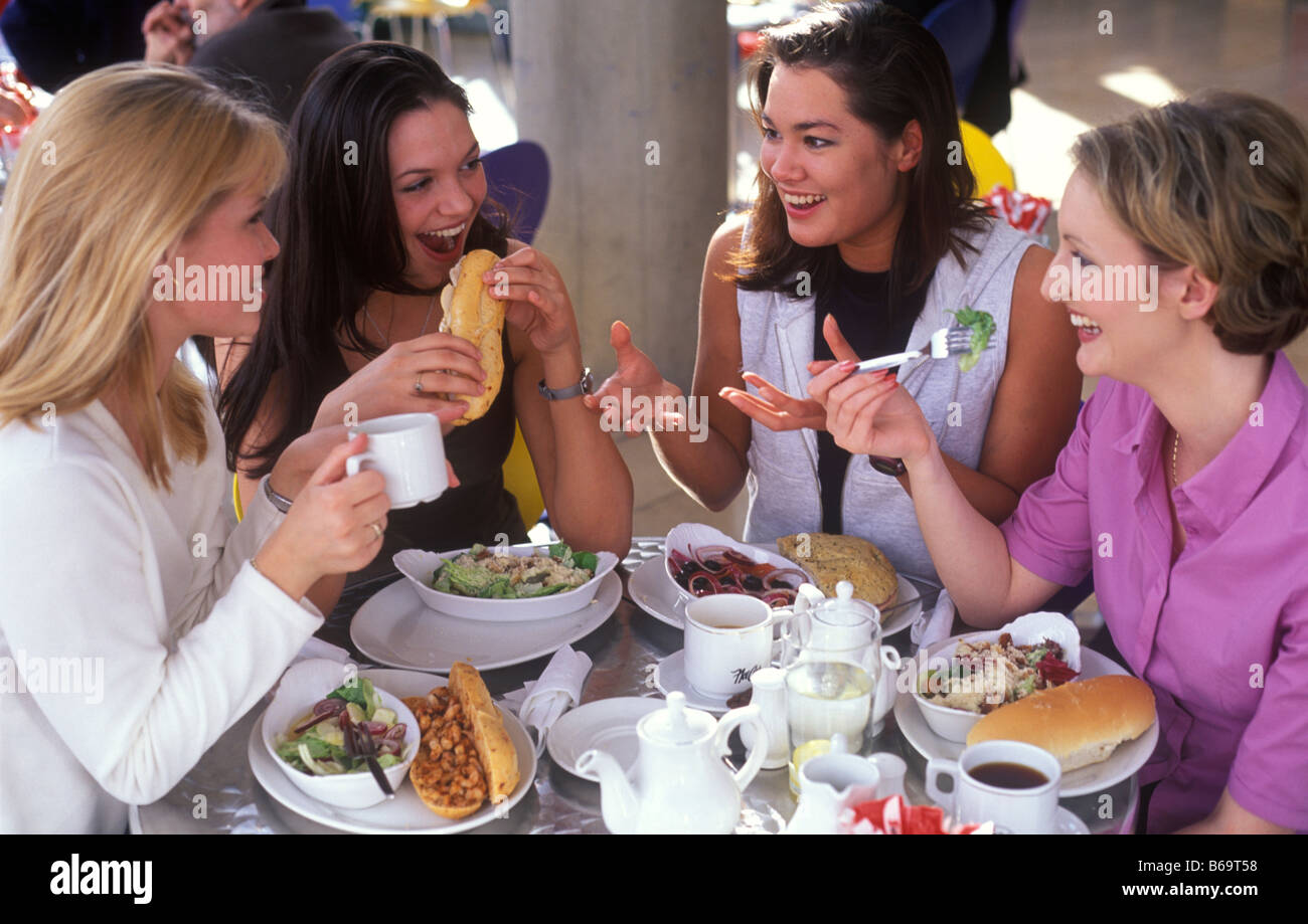 vier junge Frauen, die dem gemeinsamen Mittagessen in einem café Stockfoto