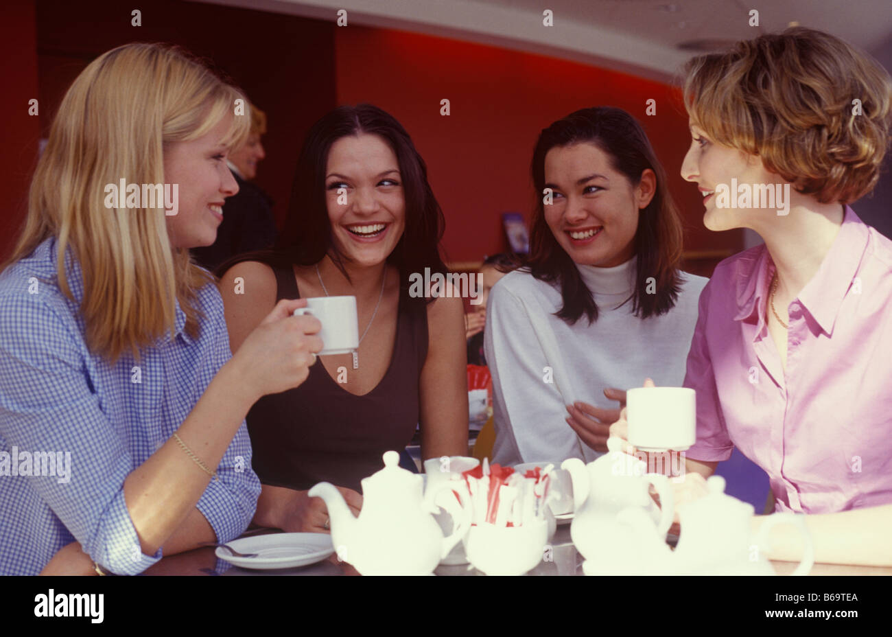 vier junge Frauen plaudern bei einer Tasse Tee Stockfoto