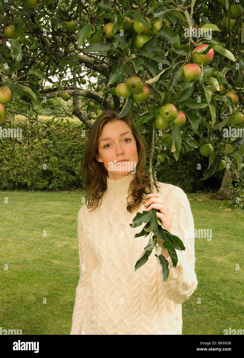 Eine junge Frau unter einem Apfelbaum Stockfoto