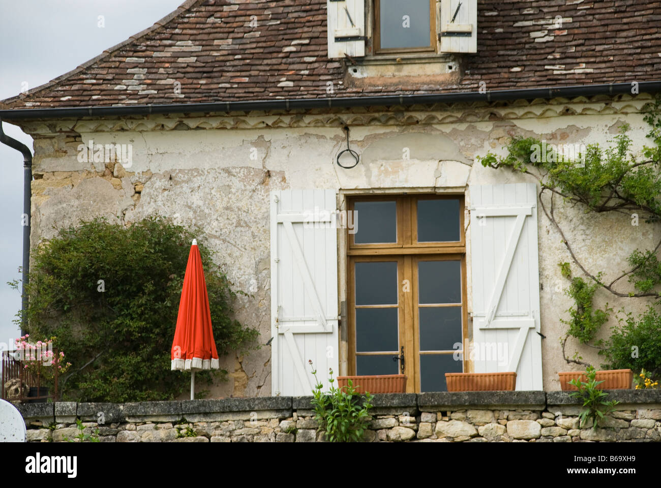 Französische Haus außen mit rotem Sonnenschirm in Frankreich Stockfoto