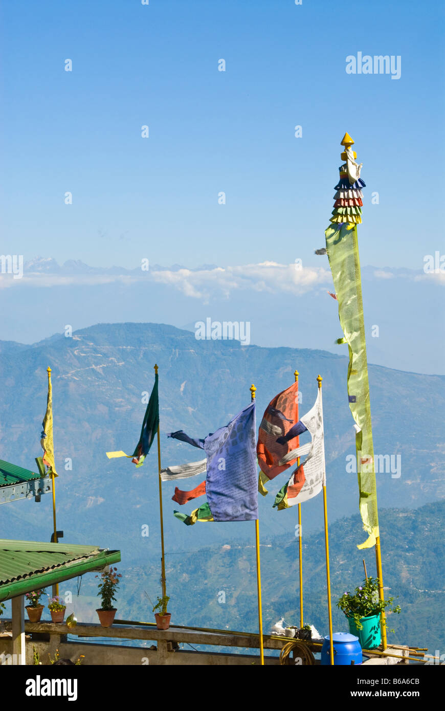 Gebetsfahnen auf dem Dach eines Hauses in Darjeeling, mit Blick auf ferne Berge Stockfoto