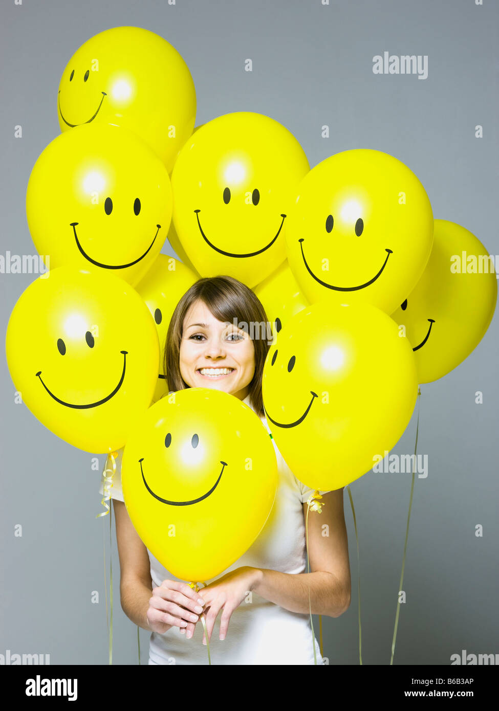 Frau mit Smiley-Gesicht-Ballons Stockfoto