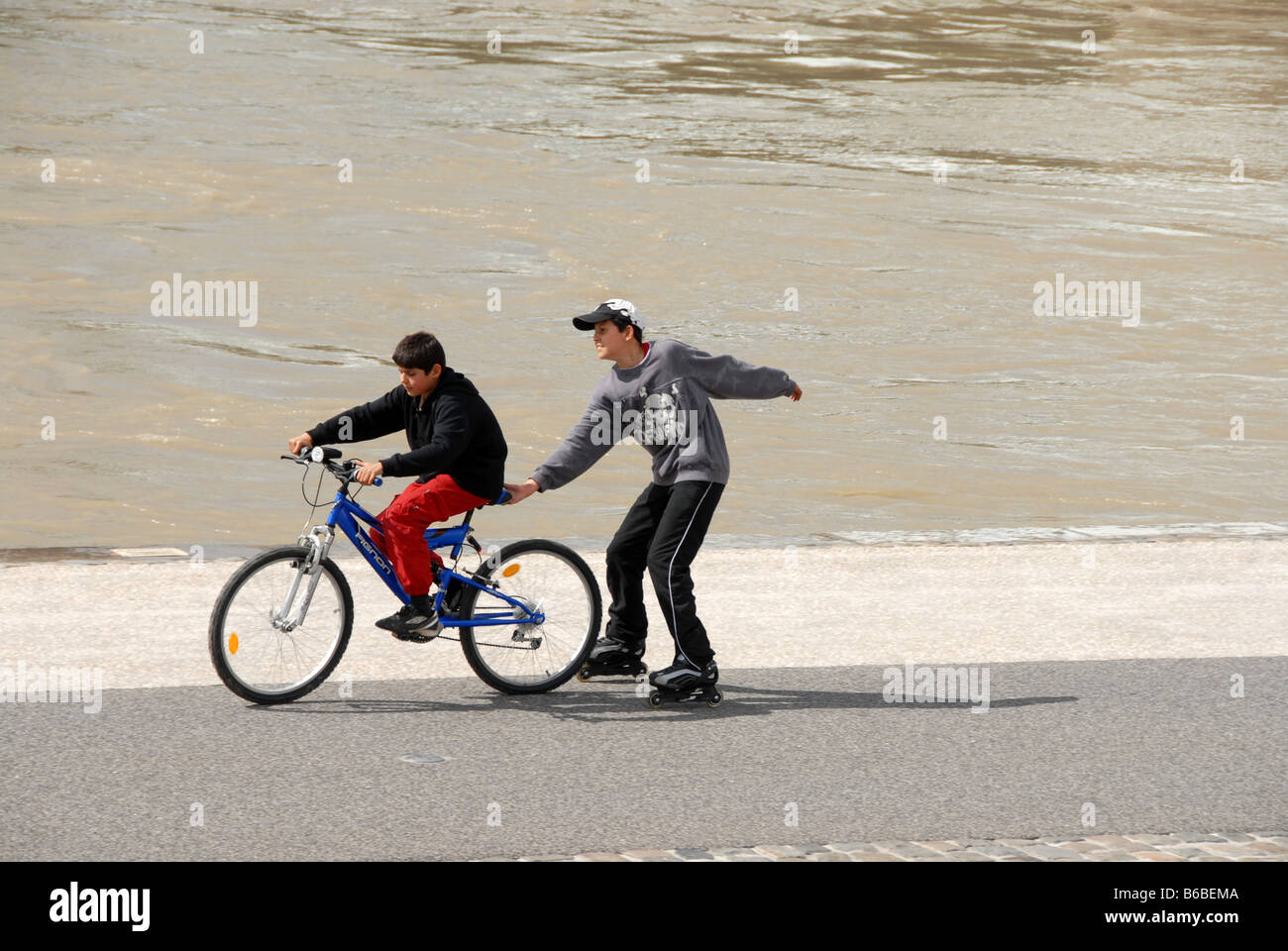 Zwei jungen amüsieren sich auf dem Zyklus verfolgen an den Ufern der Rhône in Lyon, Frankreich Stockfoto