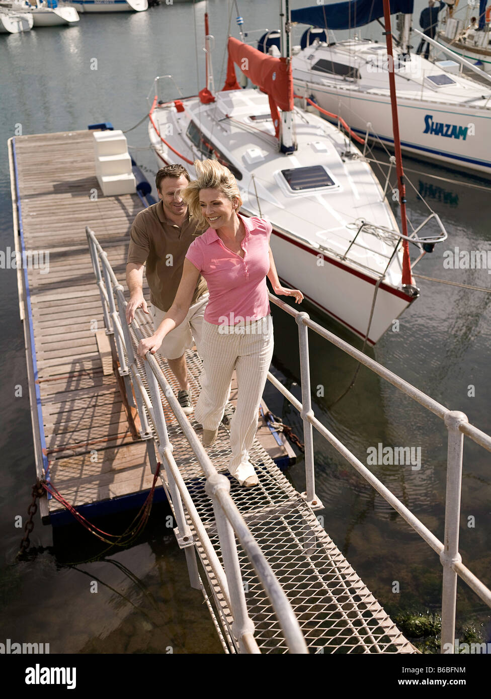 Paare, die auf der Plattform am Hafen Stockfoto