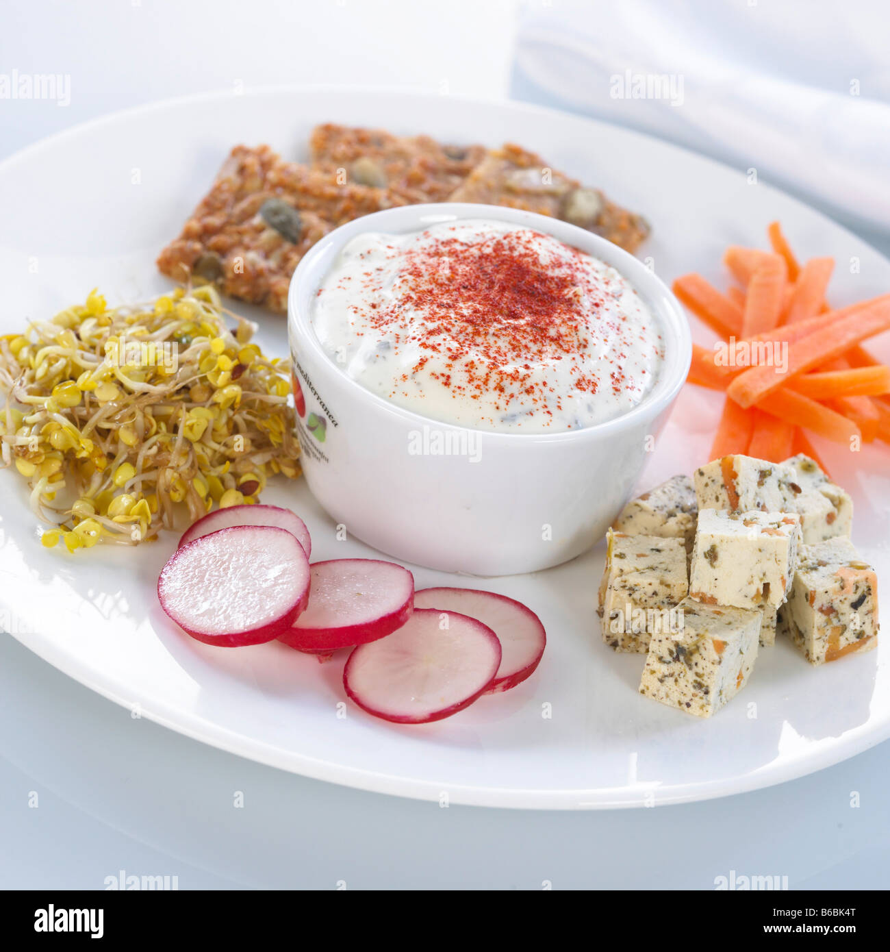 Nahaufnahme der Schüssel Quark mit Käse und Radieschen auf Platte Stockfoto