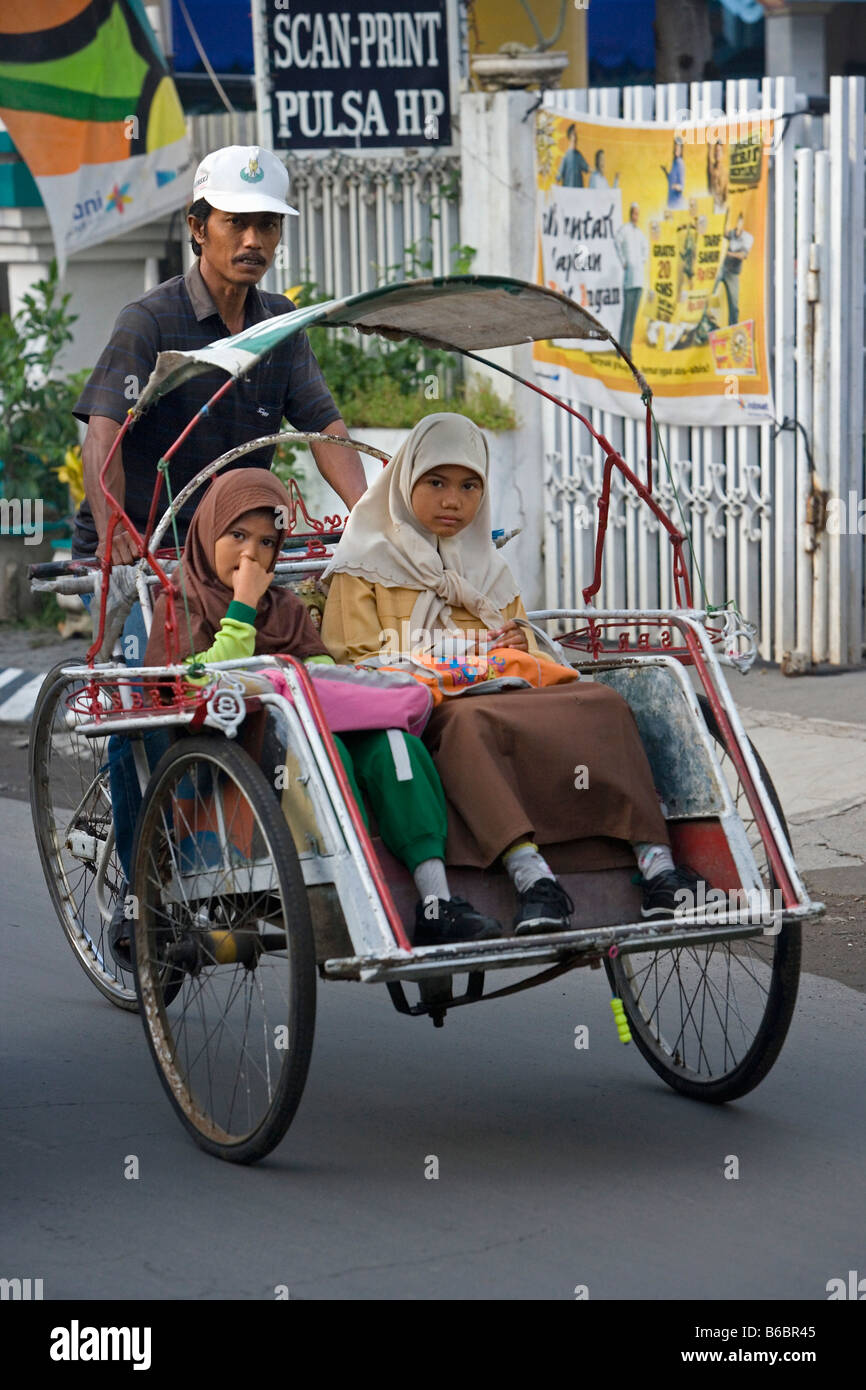 Indonesien Surabaya, Java, Quartier Jambangan Zyklus Rikscha mit zwei muslimischen Mädchen. Stockfoto