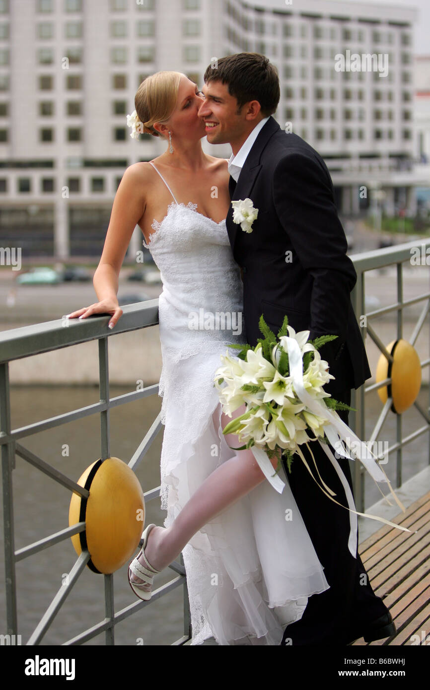 Nahaufnahme von Brautpaar gelehnt Geländer durch Wasser im urbanen Szene Stockfoto