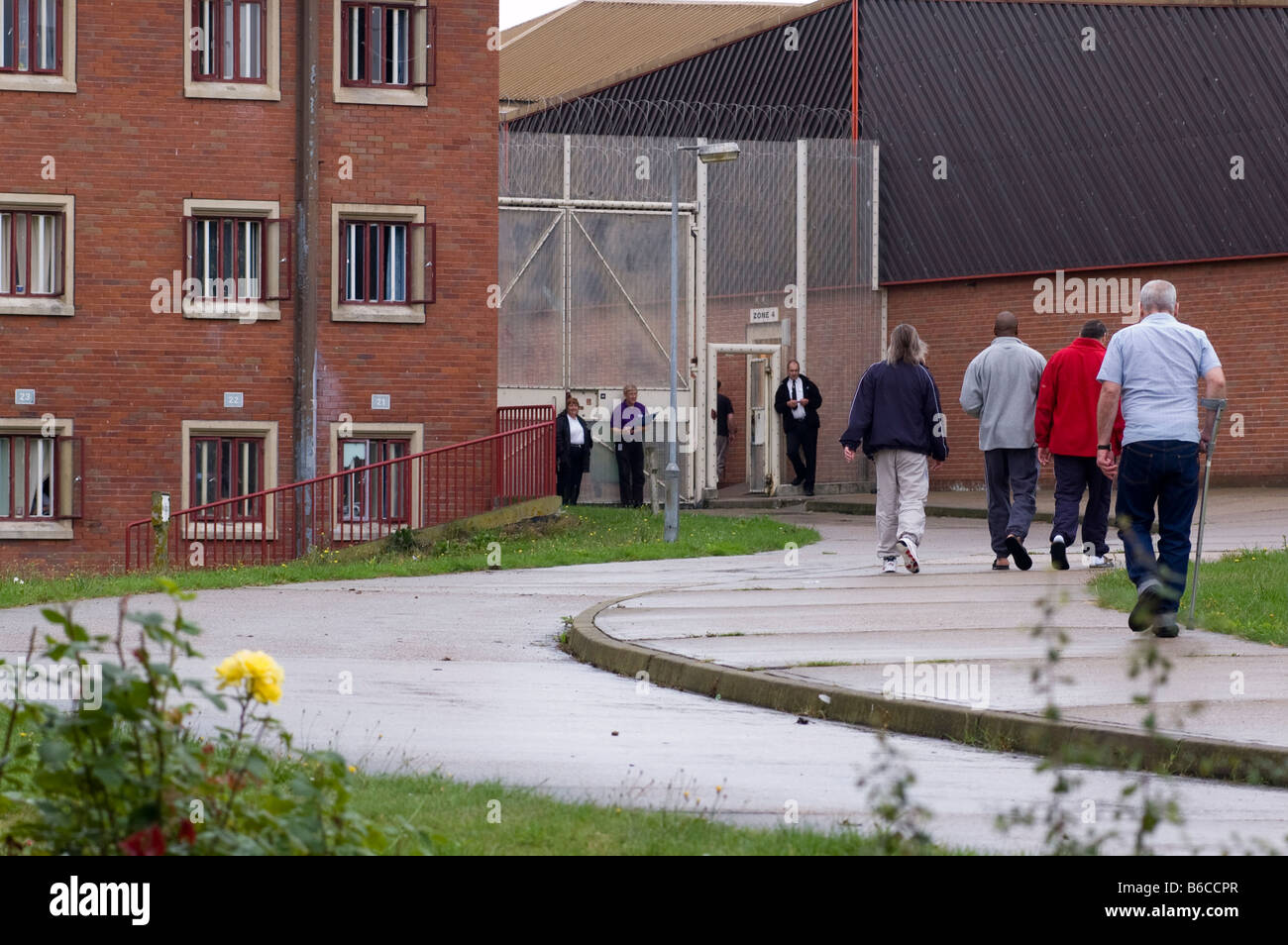 Häftlinge zu Fuß draußen zwischen Bereichen Stockfoto