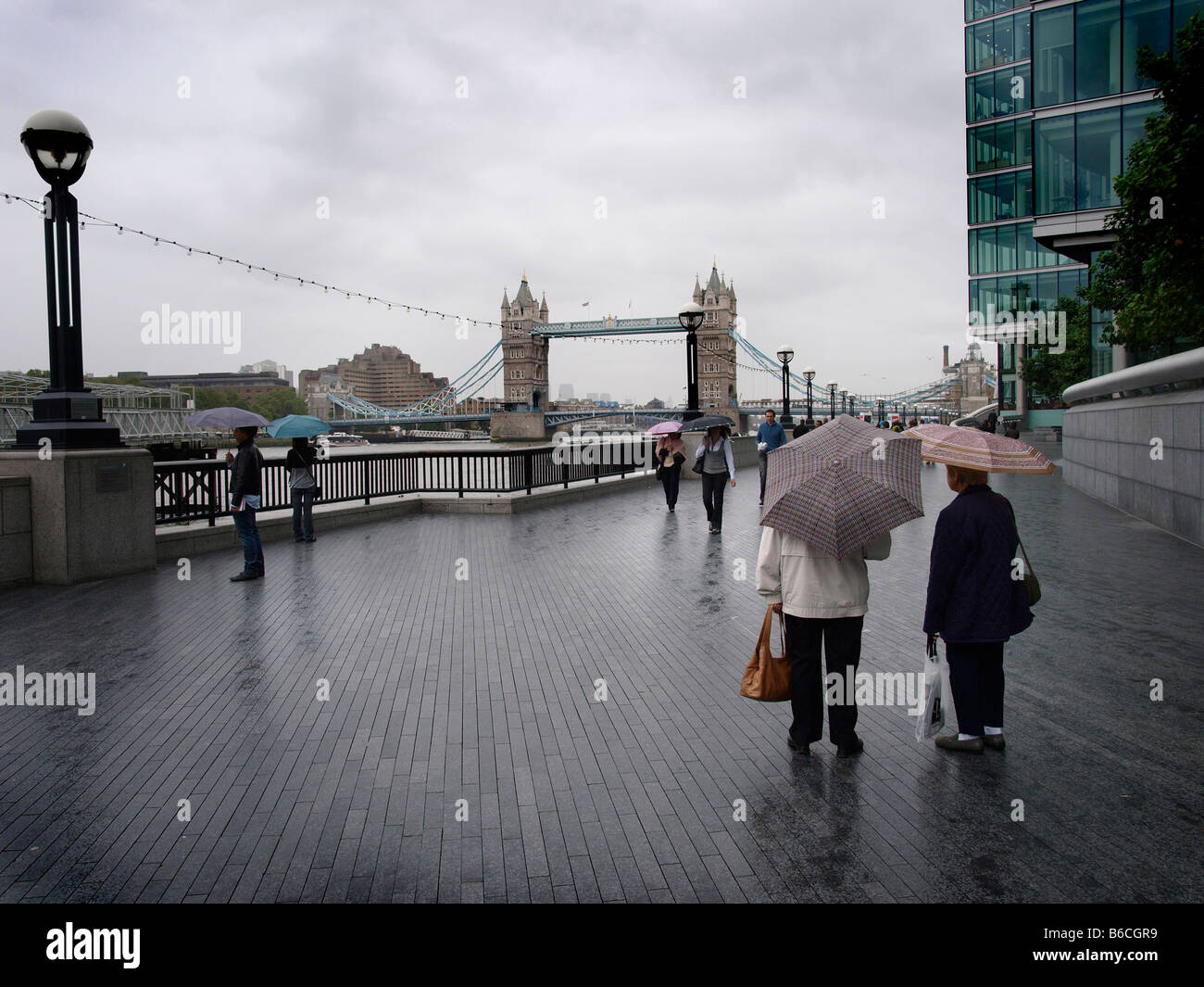 Besucher im Regen Tower Bridge London Touristen Sonnenschirme Stockfoto