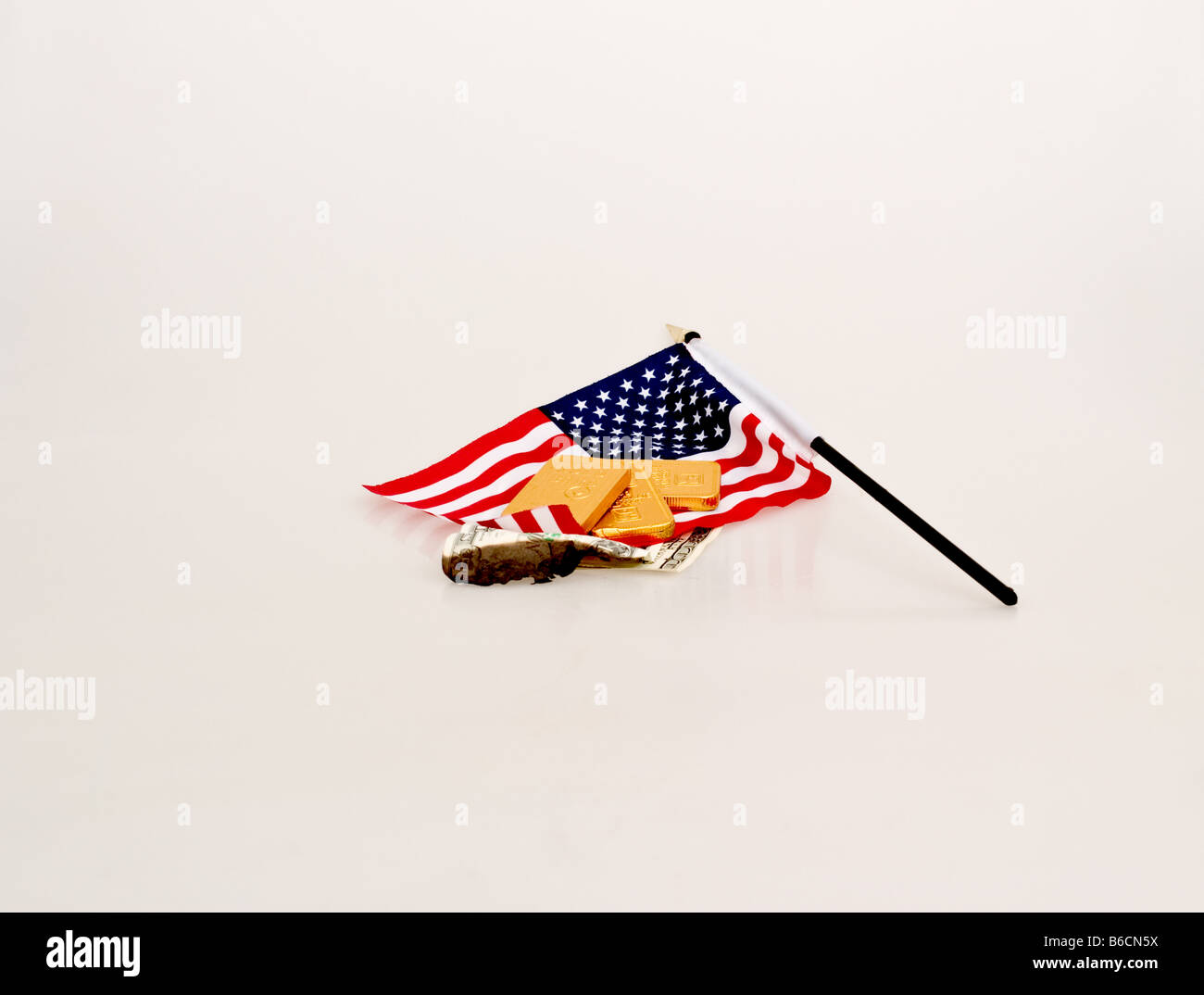 Kleine amerikanische Flagge mit einer gefälschten Goldbarren auf eine Verbrennung gefälschte million-Dollar-Schein Stockfoto