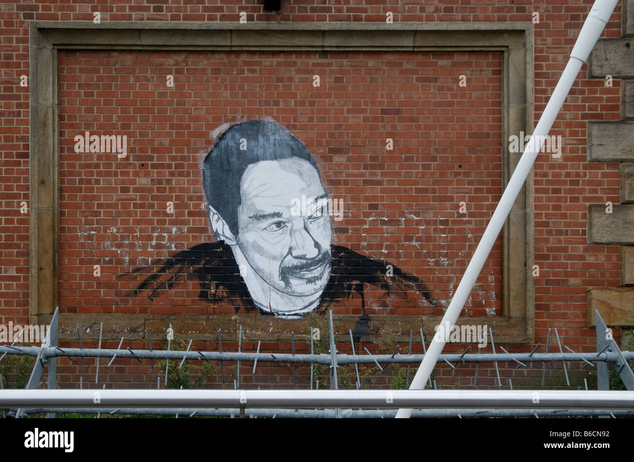 Riesigen Graffiti Kopf und Schultern des Mannes hinter Sicherheitszaun auf Hungerford Eisenbahn- und Fußgängerbrücke, London Stockfoto