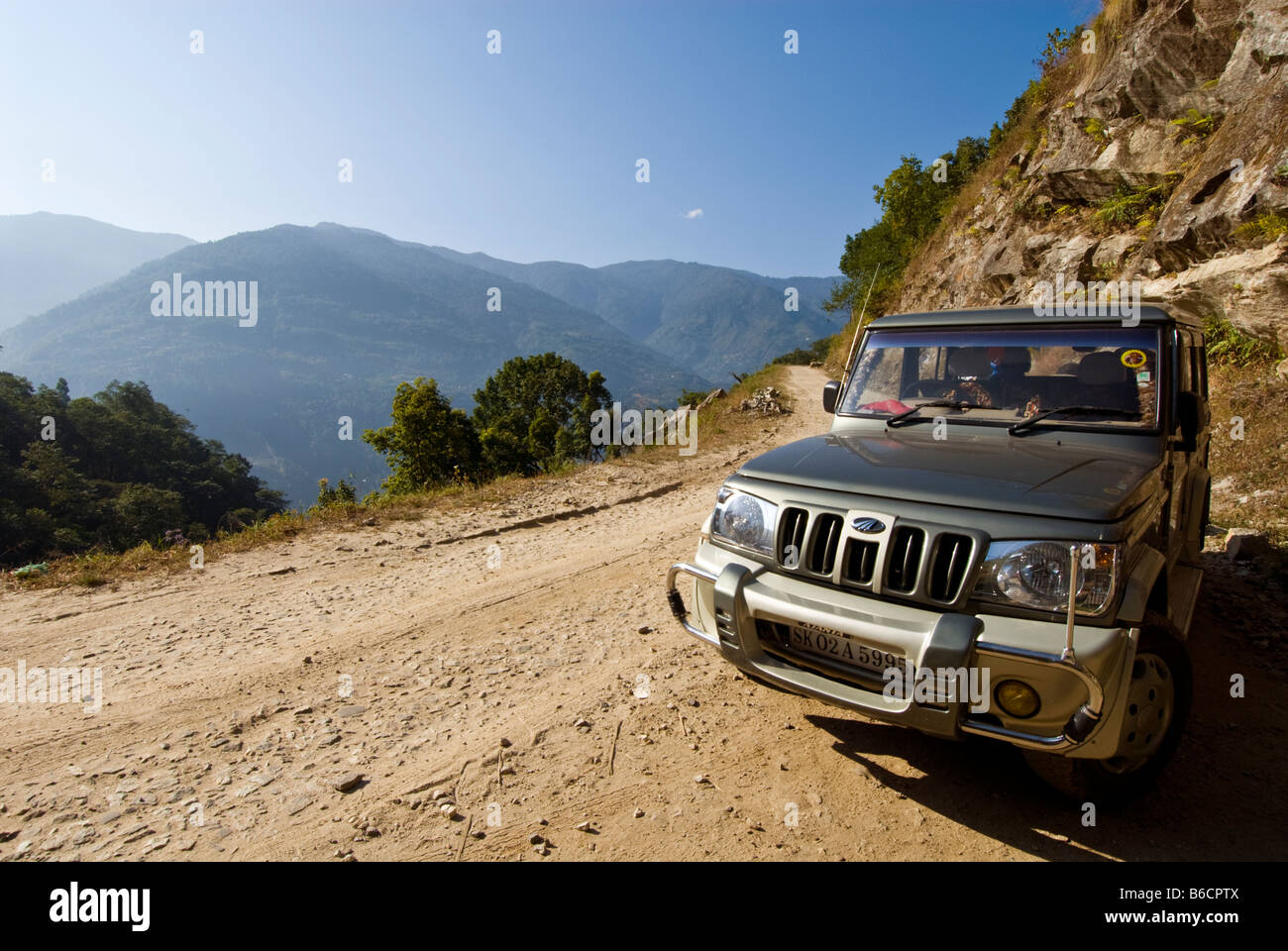 Ein Jeep auf einer staubigen Bergstraße zwischen Dentam und Pelling, Sikkim, Indien Stockfoto