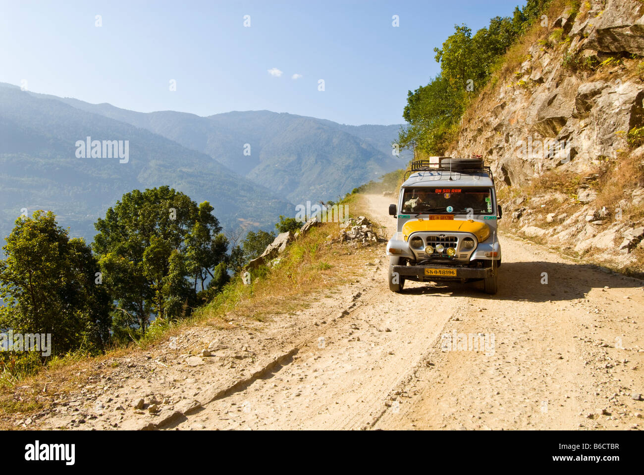 Ein Jeep auf einer staubigen Bergstraße zwischen Dentam und Gayzing, Sikkim, Indien Stockfoto