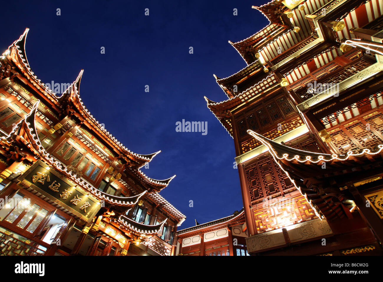 Niedrigen Winkel Blick auf Gebäude leuchtet in der Nacht, Yuyuan Garten Bazaar, Shanghai, China Stockfoto