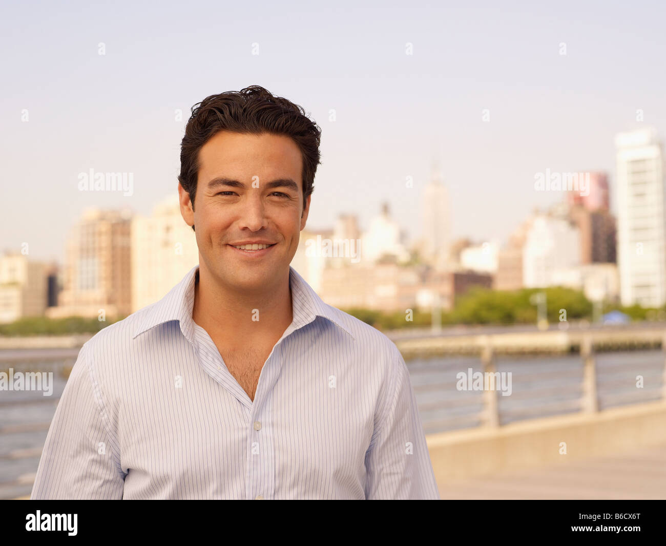 Mann steht am Ufer mit Stadtbild im Hintergrund Stockfoto