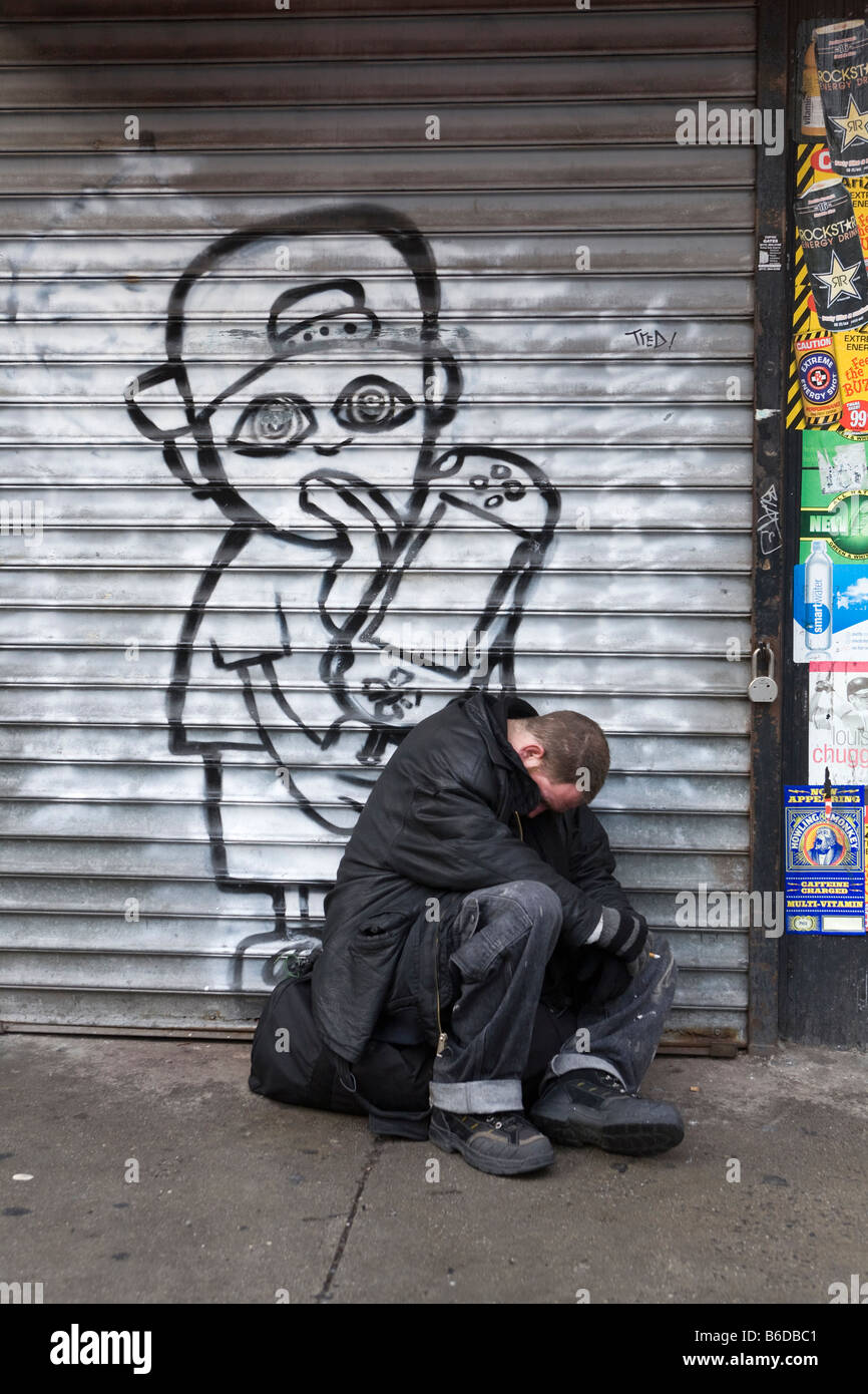 Mann schläft auf dem Bürgersteig mitten am Tag auf der 8th Avenue in New York City Stockfoto
