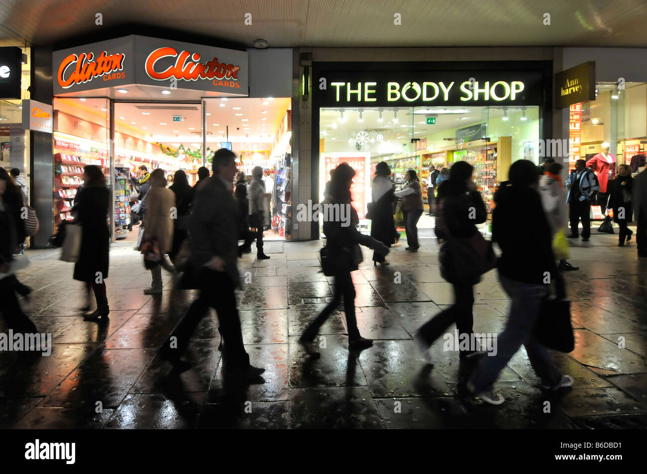 The Body Shop vor dem Einzelhandelsgeschäft Oxford Street Abendeinkäufer nasser Regen Pflaster vor Clinton Cards London West End England UK Stockfoto