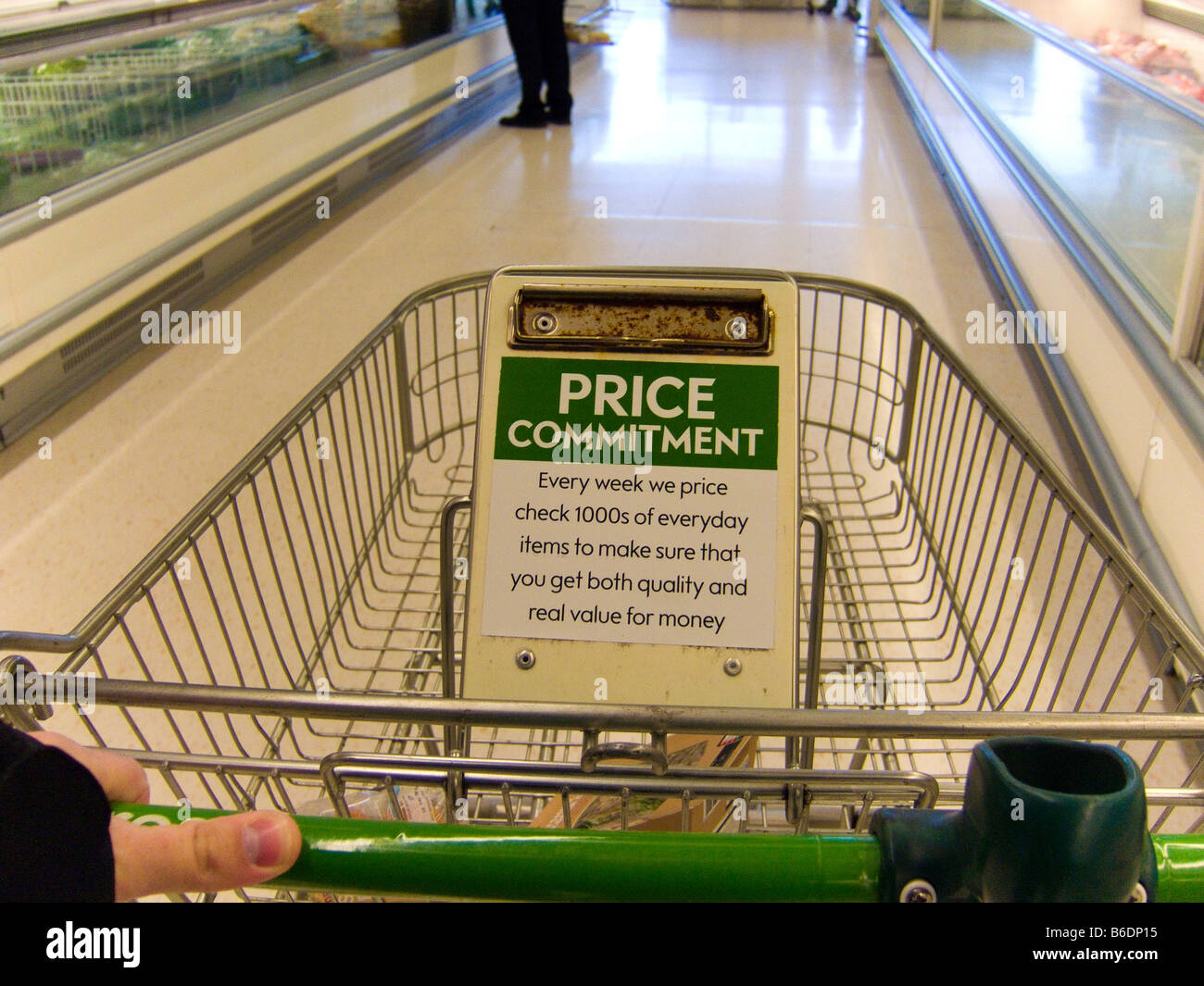 Ein Einkaufswagen im Supermarkt mit einem Preis-Vergleich-Versprechen-Schild Stockfoto