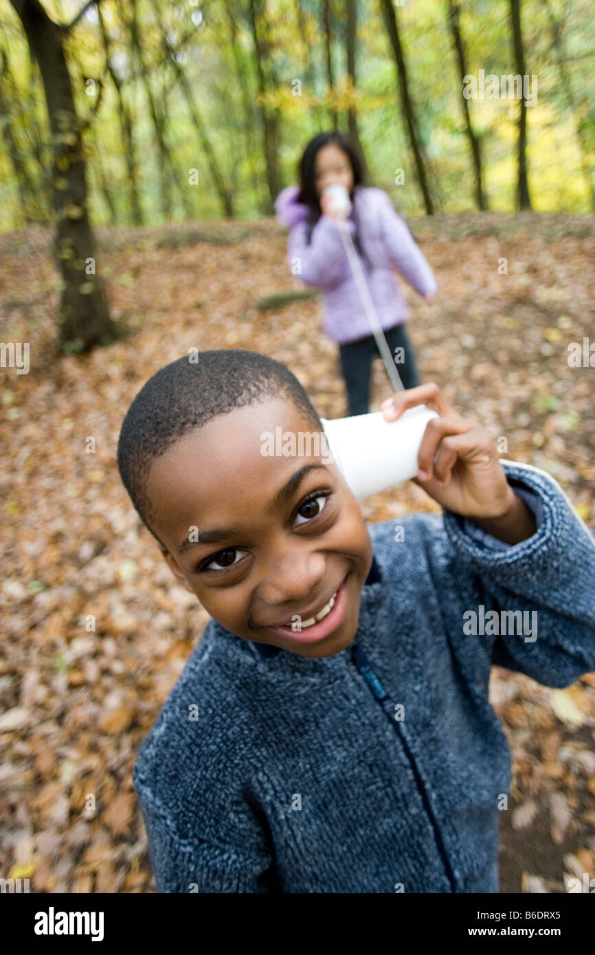 Tasse-String Telefon durch ein Junge und ein Mädchen in einem Wald im Herbst verwendet wird. Stockfoto