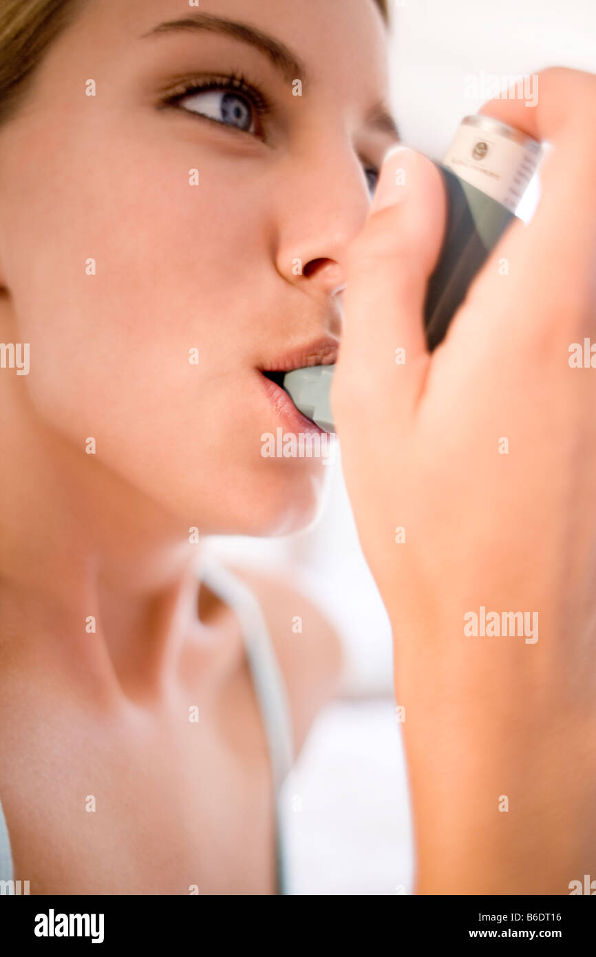 Asthma-Inhalator verwenden. Junge Frau mit einem Inhalator, um einen Asthma-Anfall zu behandeln. Stockfoto