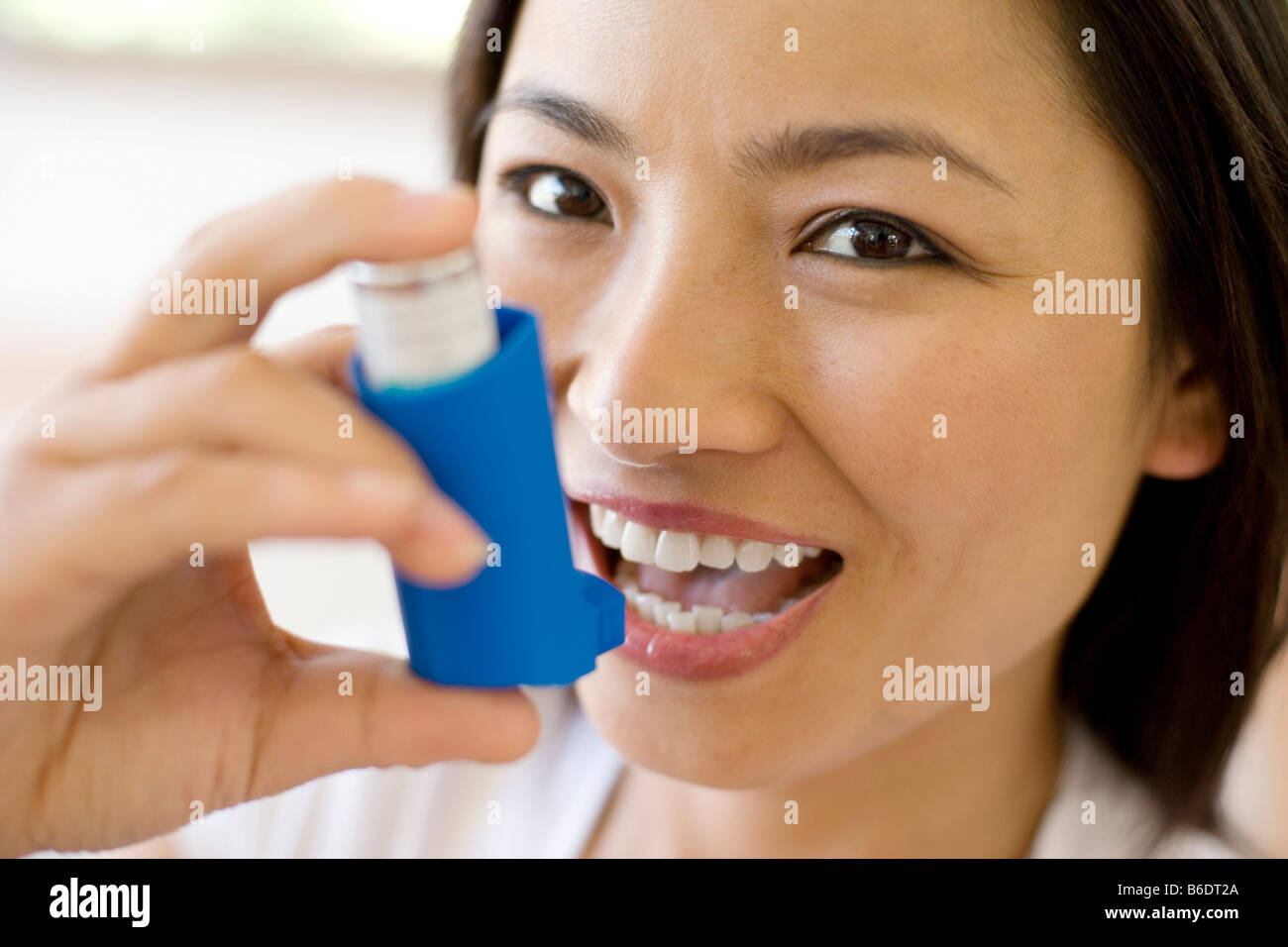 Asthma-Inhalator verwenden. Frau mit einem Inhalator, um einen Asthma-Anfall zu behandeln. Der Inhalator enthält bronchienerweiternde Medikamente. Stockfoto