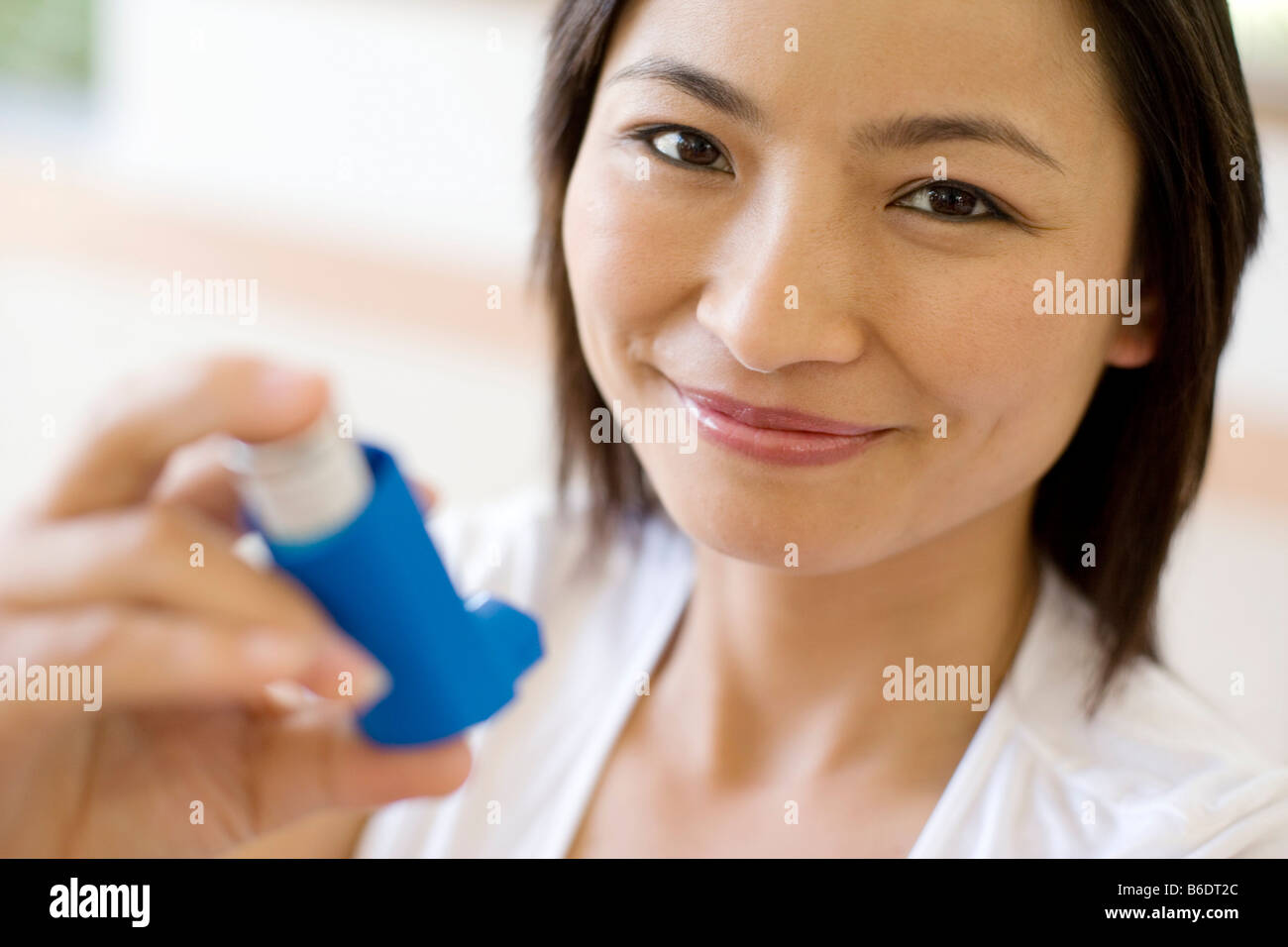 Asthma-Inhalator verwenden. Frau mit einem Inhalator, um einen Asthma-Anfall zu behandeln. Der Inhalator enthält bronchienerweiternde Medikamente. Stockfoto
