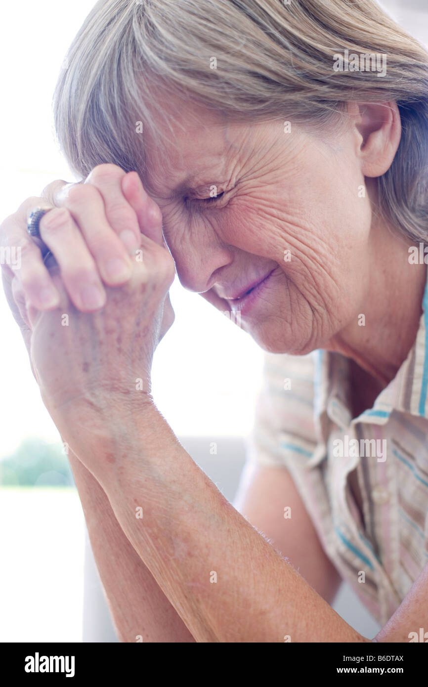 Stress. Unglückliche Frau ihre Hände gegen die Stirn drücken. Stockfoto