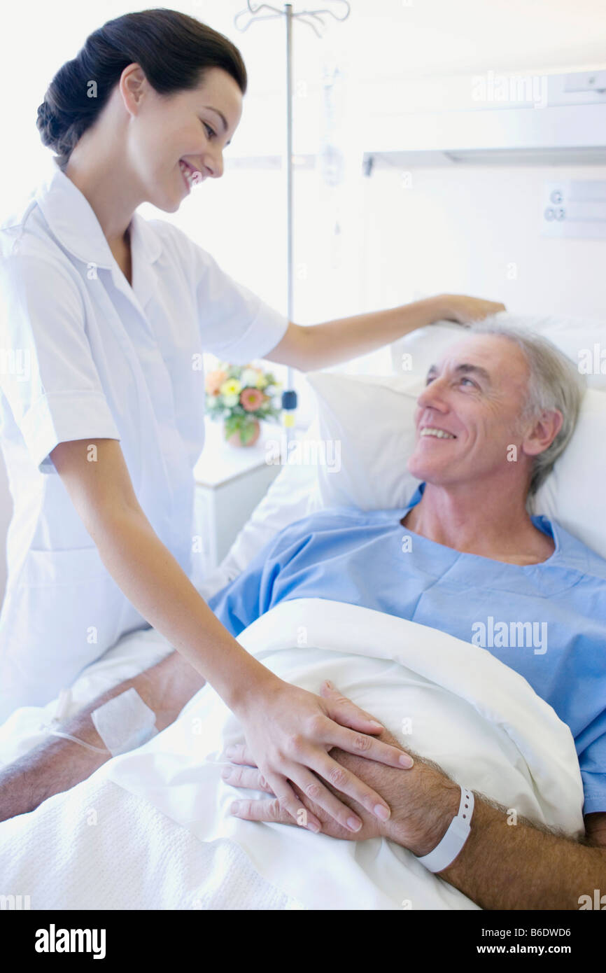 Versorgung der Patienten. Krankenschwester beruhigend ein Patient auf einer Krankenstation. Stockfoto