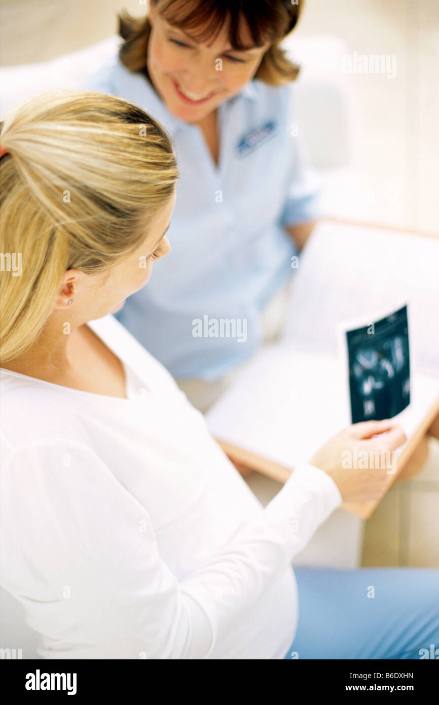 Geburtshilfliche Untersuchung. Hebamme und eine schwangere Frau Ultraschallbilder von ihrem Fötus zu betrachten. Stockfoto