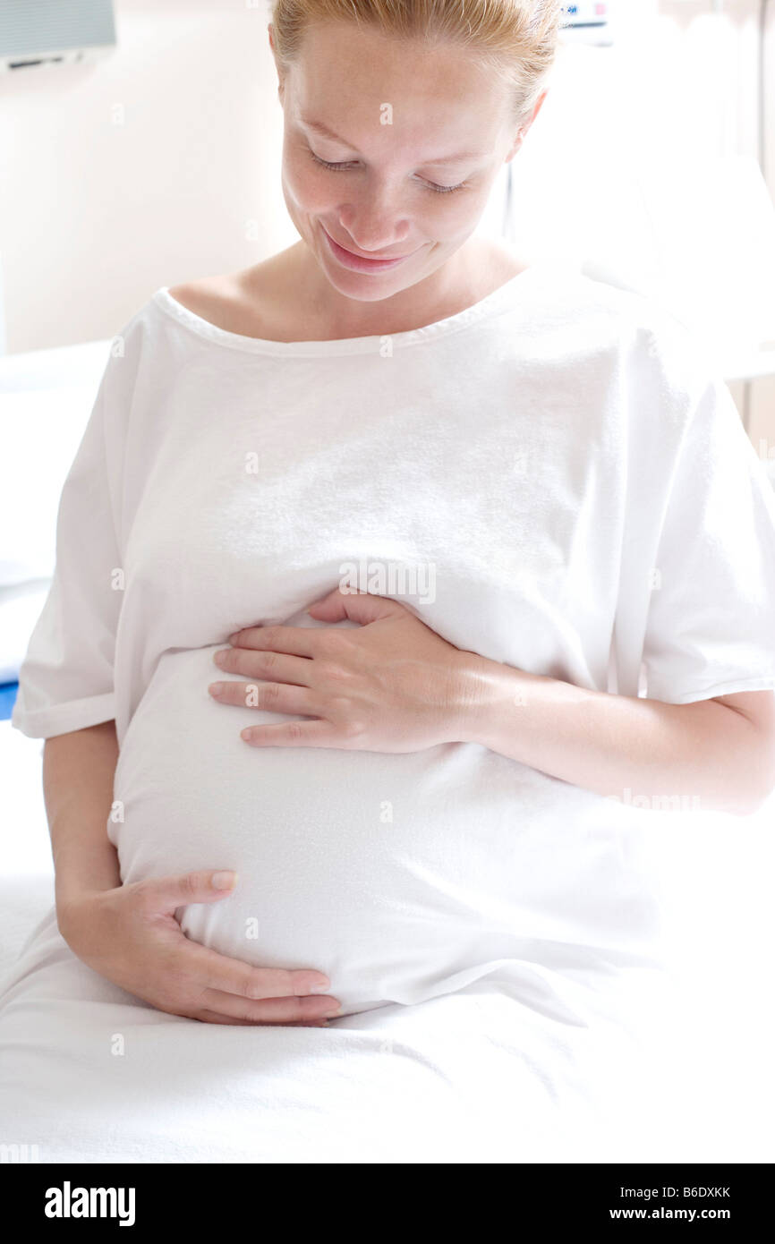 Schwangere Frau in einer Entbindungsstation halten ihre geschwollenen