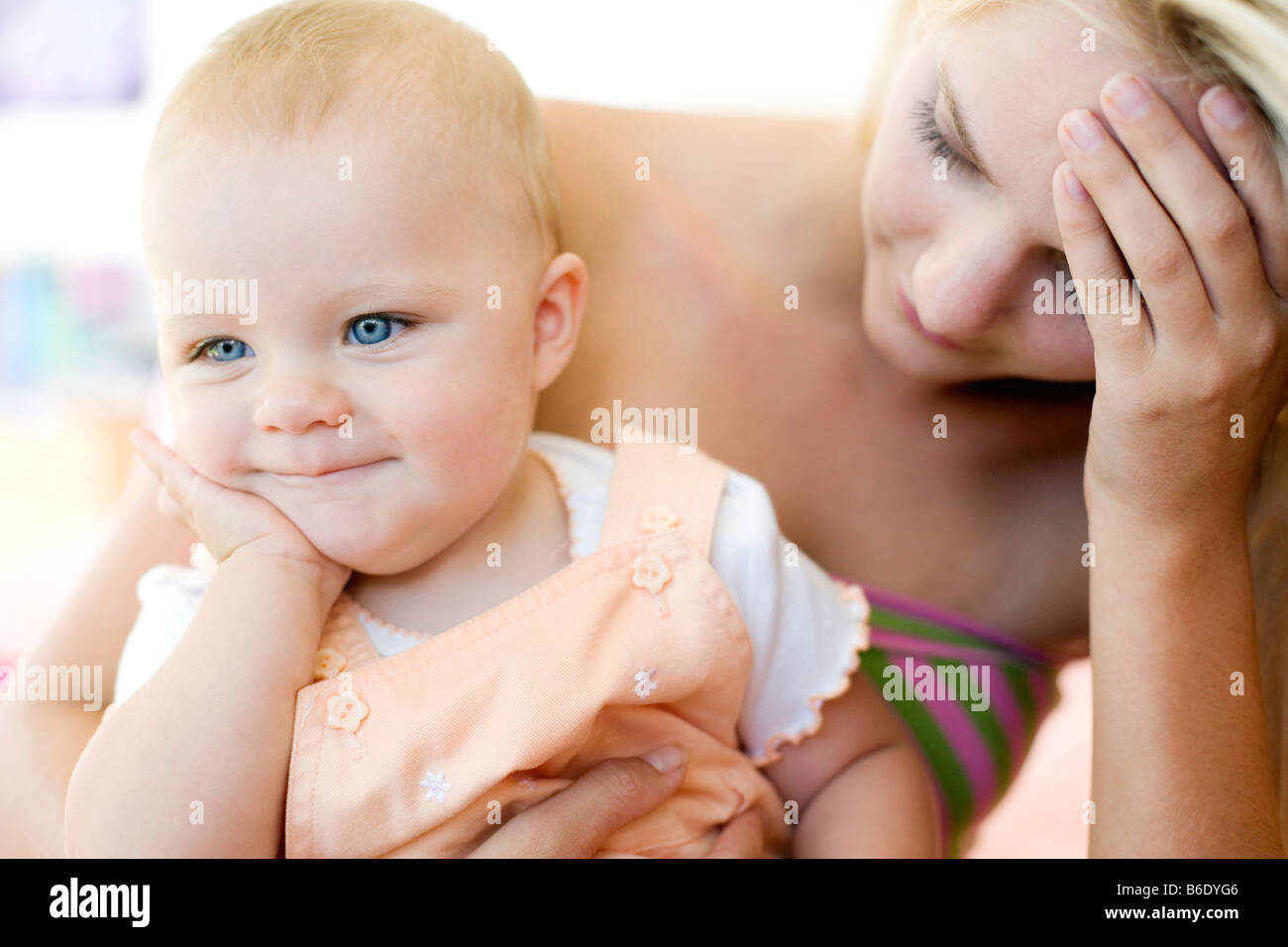 Teenager-Mutter und Baby. Junge Mutter hält ihr 10 Monate alte Tochter betonte. Gestellt von Modellen. Stockfoto