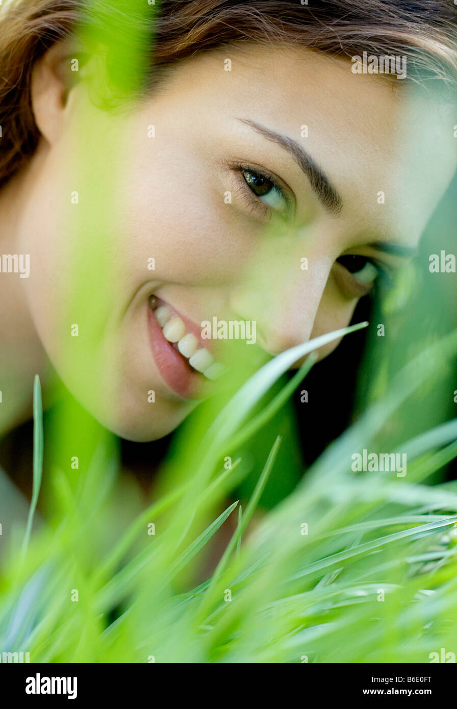 Frau lächelnd durch Rasen Stockfoto