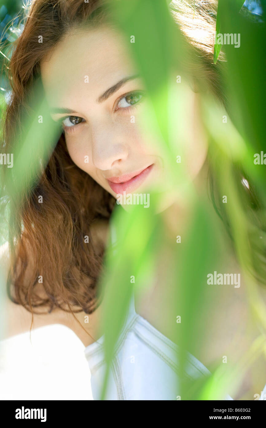 Frau auf der Suche durch Blätter Stockfoto