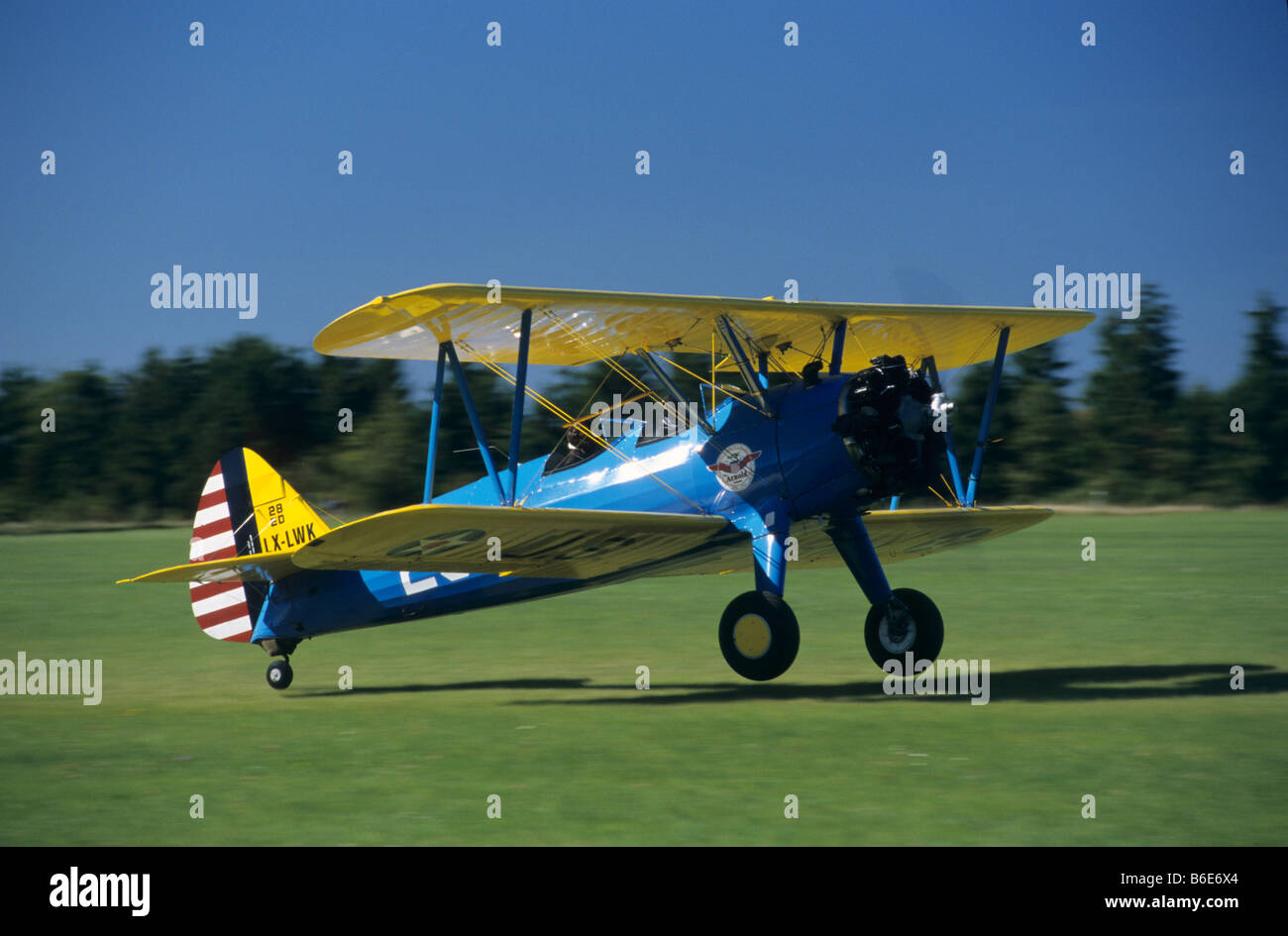Alte amerikanische Trainer Doppeldecker Boeing PT-17 Kaydet / Stearman Modell 75 Landung auf einem grünen Rasen-Flugplatz Stockfoto