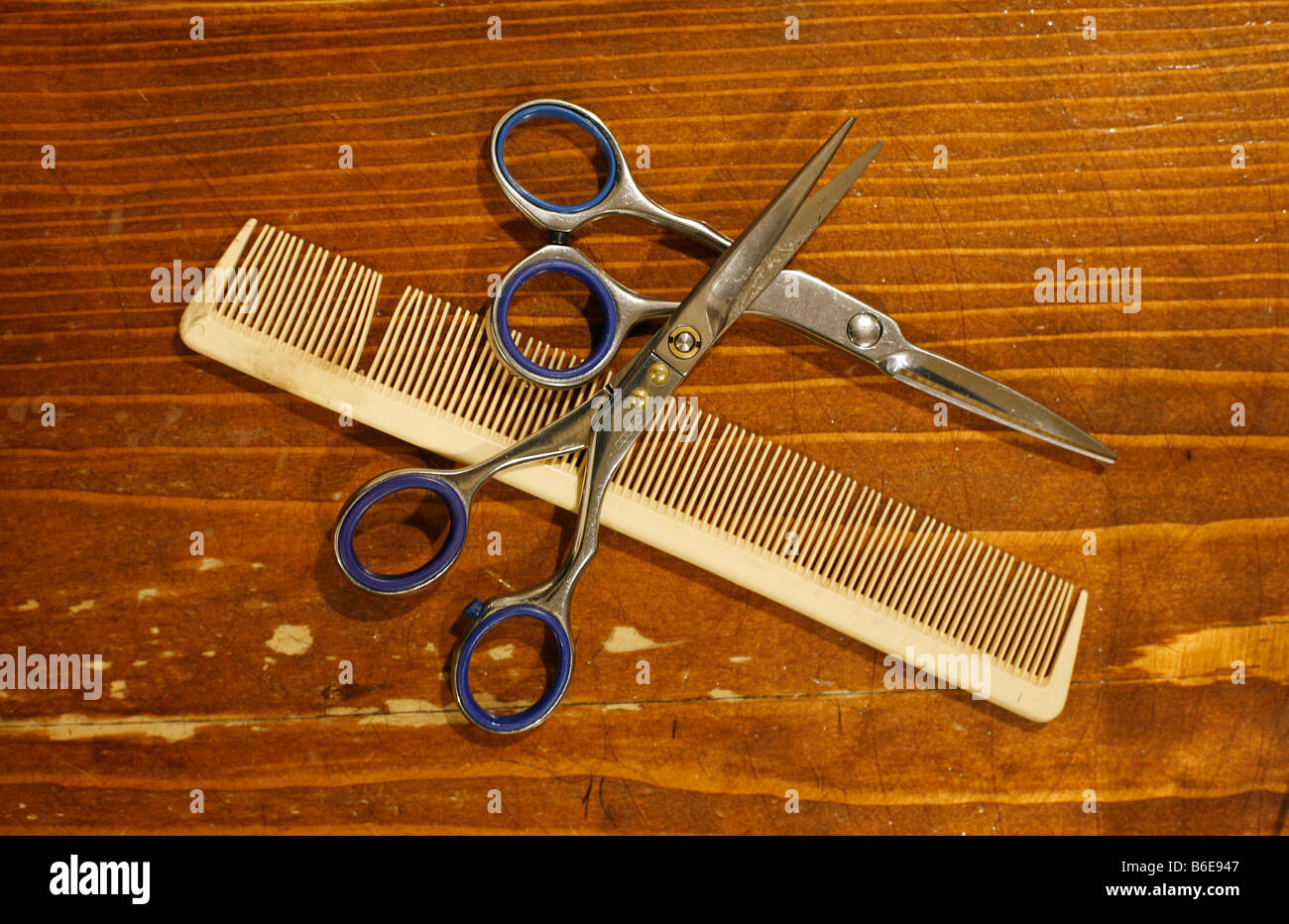 Zwei Paare von professionellen Schere und Kamm auf Holzoberfläche im salon Stockfoto
