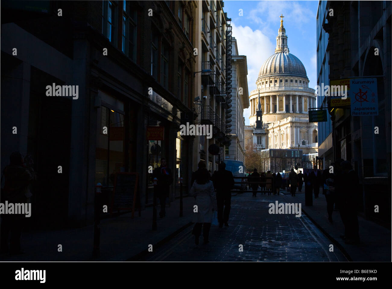 Saint Pauls Kathedrale in London mit städtischen Angestellten auf Straße in der abgedunkelten Forground. Stockfoto